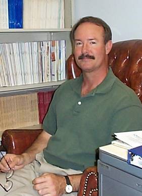 Photo of Dr. Jim Blasingame sitting in his office at Arizona State University, surrounded by books.