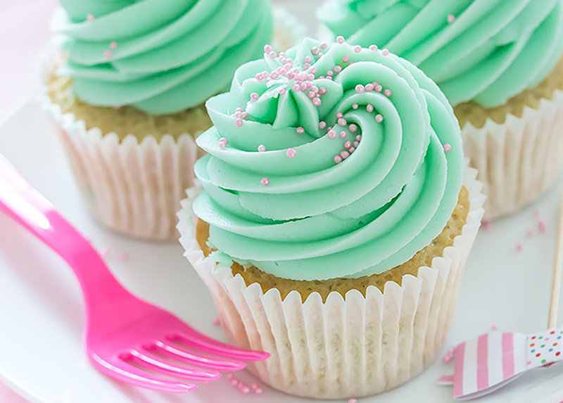 Light cupcake with a blue-green icing and sprinkles on top