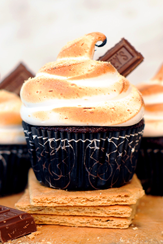 Chocolate cupcake topped with a toasted marshmallow frosting and topped with a small piece of chocolate